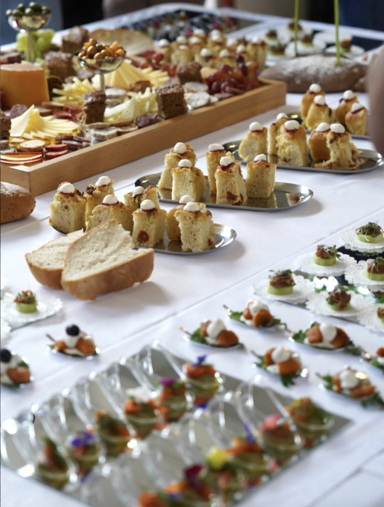 Mesa de catering con canapés, quesos y pequeños bocados para un evento